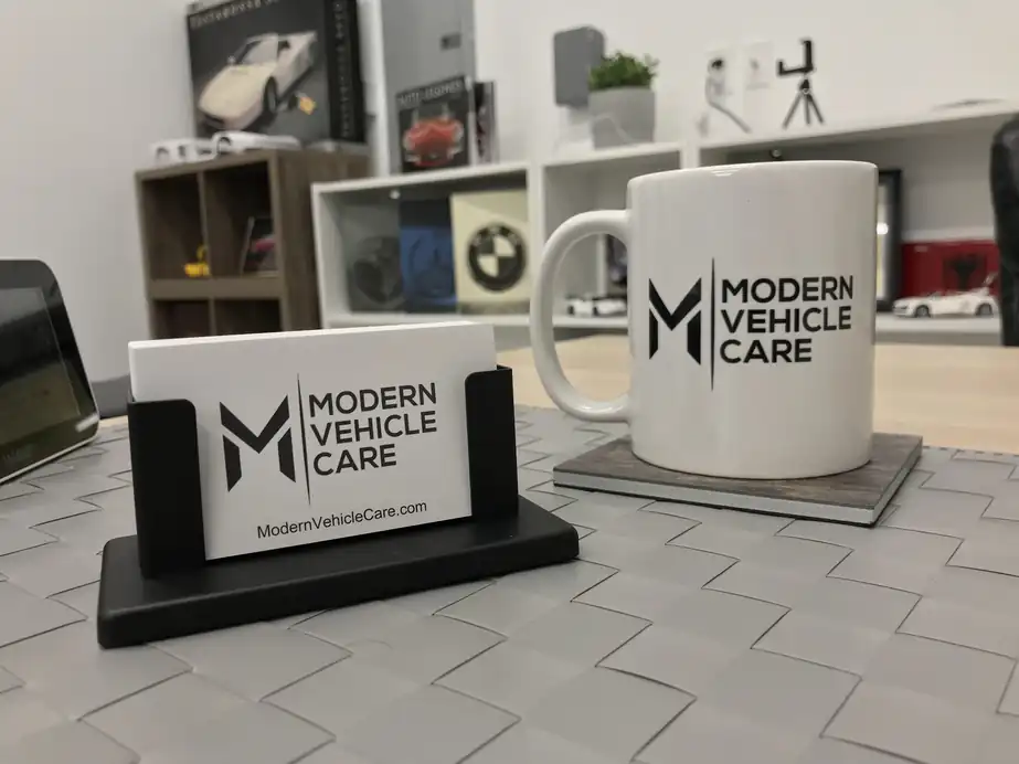 Modern Vehicle Care business card and branded mug on the shop desk
