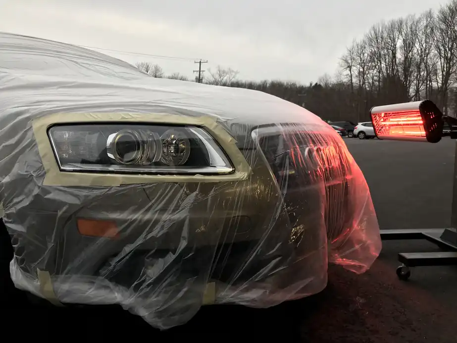 Audi headlight taped off under plastic, close-up