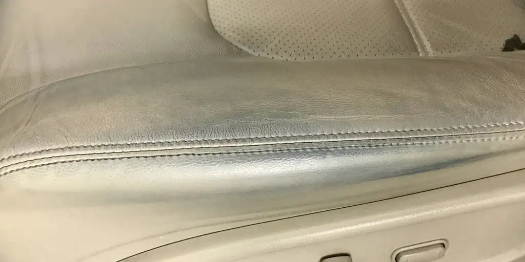Worn, creased light leather seat bolster