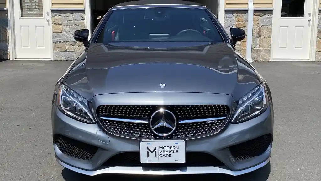 Grey Mercedes C43 coupe parked head-on outside the shop